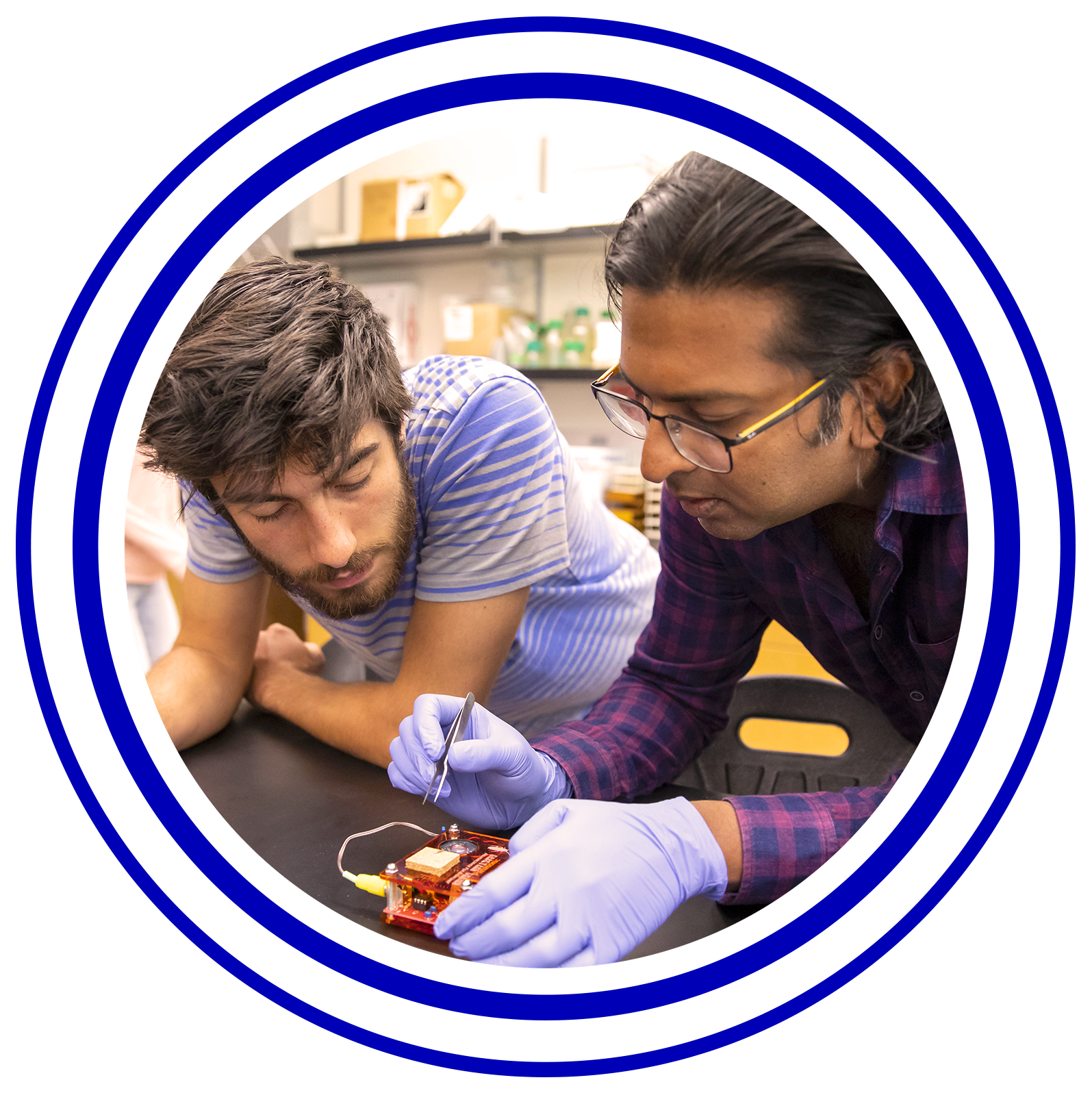 Circular image with colorful rings around it of a student and professor working on a motor.