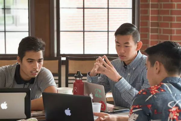Three students work together on a project.